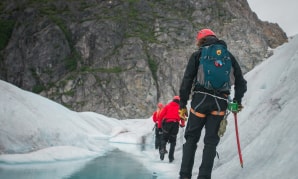 Группа людей, идущих по заснеженной тропинке.