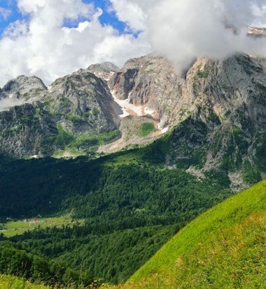 Река, протекающая через долину с горами на заднем плане.